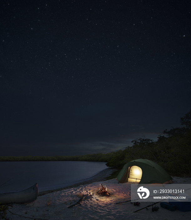 tent and campfire by the sea at night