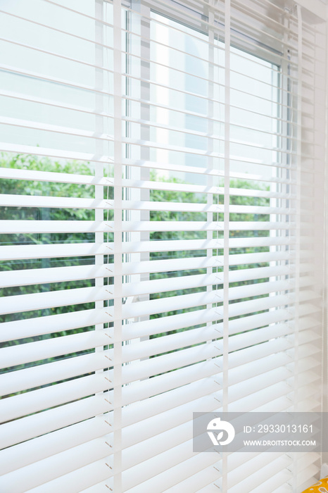 Close up view of window with horizontal blinds. White Roller Blinds or Louver curtains at the glass window