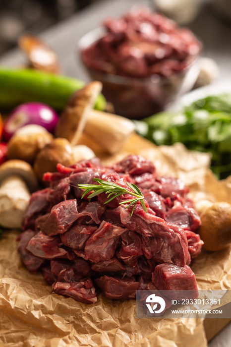 Sliced deer meat prepared for stew of game forest mushrooms herbs and vegetables