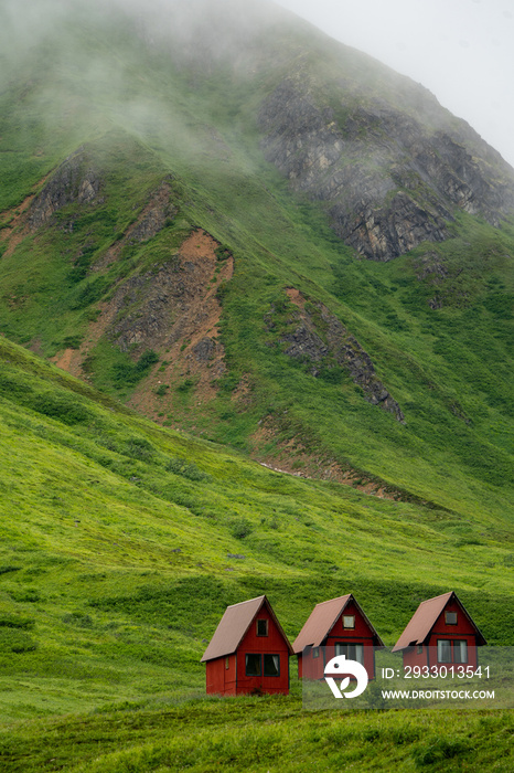 Abandoned red cabins sit in the green lush mountains of Alaska’s Hatcher Pass near Independence Mine.