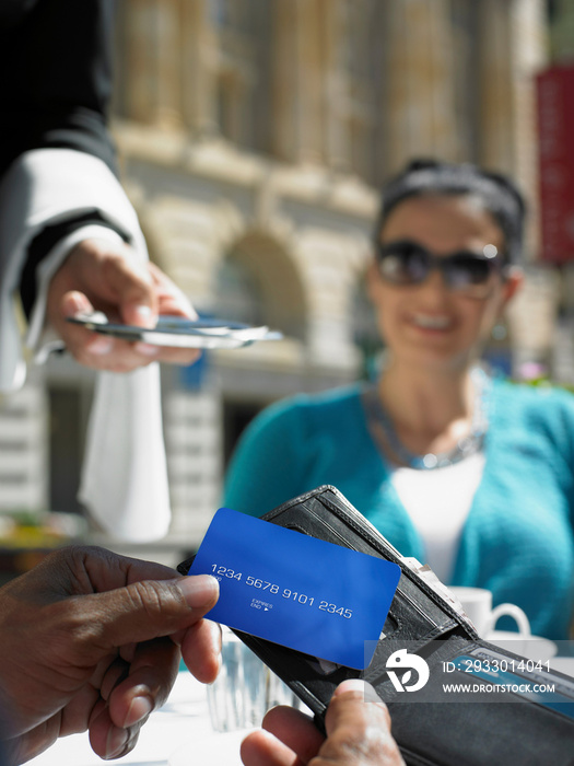 Woman smiling at friend making credit card payment