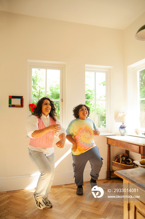 Curvy mother dancing with her son in the kitchen