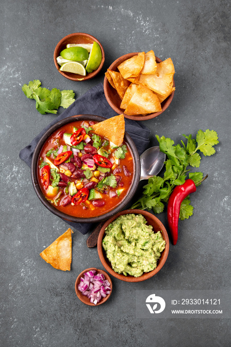 Mexican food concept background with chile black bean soup, guacamole and nachos totopos. Top view