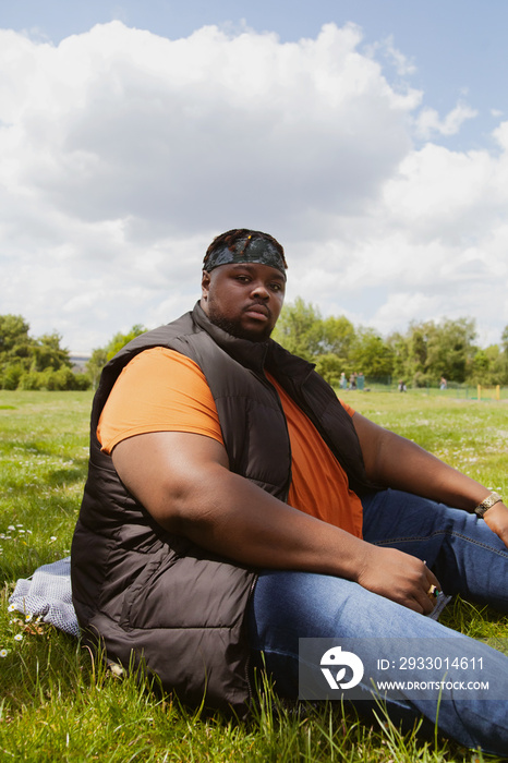 Plus-sized sitting in the park and staring at the camera