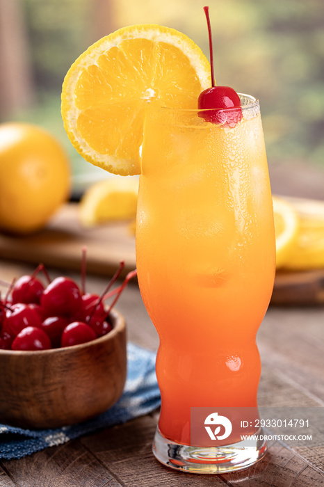 Tequila sunrise cocktail with cherry and orange slice