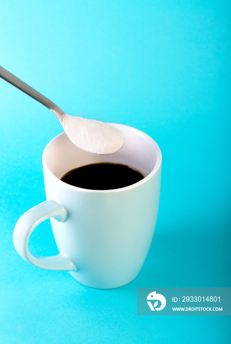 Morning coffee and a spoon with collagen powder on blue background.