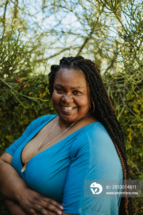 close up portrait of a plus size Afro Latinx Haitian American woman smiling wearing blue