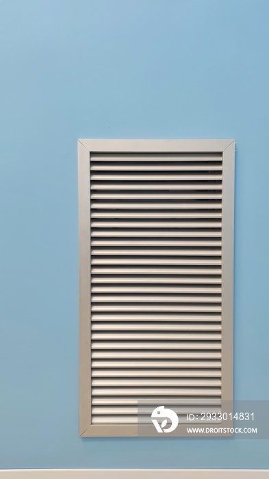 square metal ventilation grate in a blue wall, close view, delivers fresh air and cools