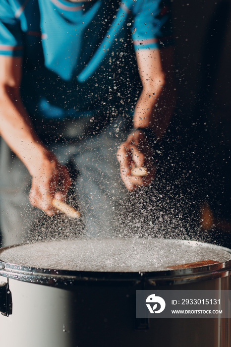 Close up drum sticks drumming hit beat rhythm on drum surface with splash water drops