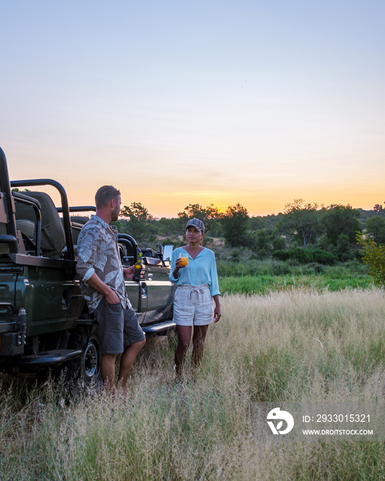 Asian women and European men on safari game drive in South Africa Kruger national park. a couple of men and women on safari. Tourist in a jeep looking sunset on safari