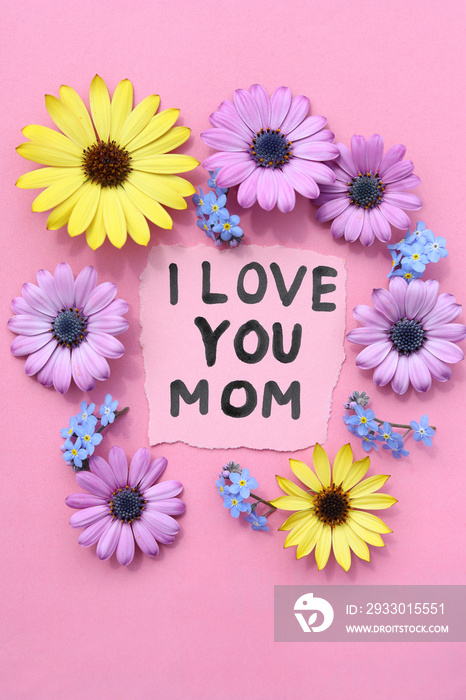 Text I love you mom with flowers on pink background.