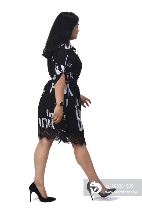 sideways of latin woman with dress and high heels walking on white background,