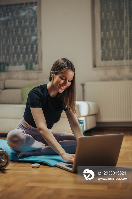 Woman using laptop while training at home