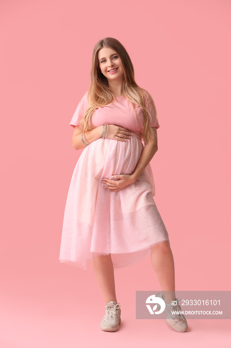 Beautiful young pregnant woman on color background