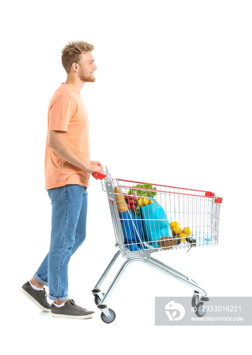 Young man with shopping cart on white background