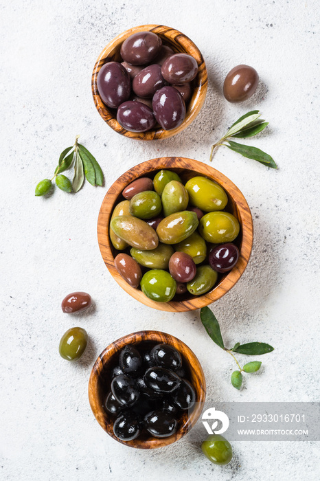 Black and green olives on white background.