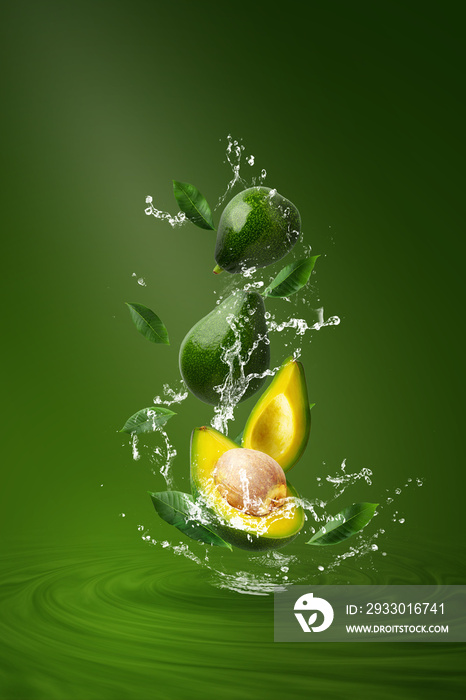 Water splashing on Fresh Sliced Green avocado over the Green background.