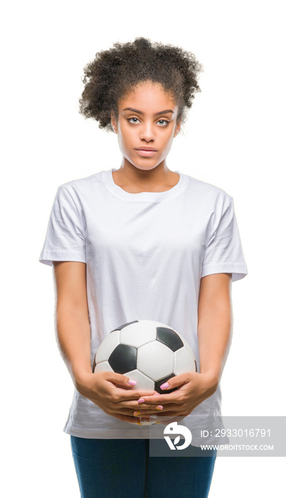 Young beautiful afro american holding soccer football ball over isolated background with a confident expression on smart face thinking serious