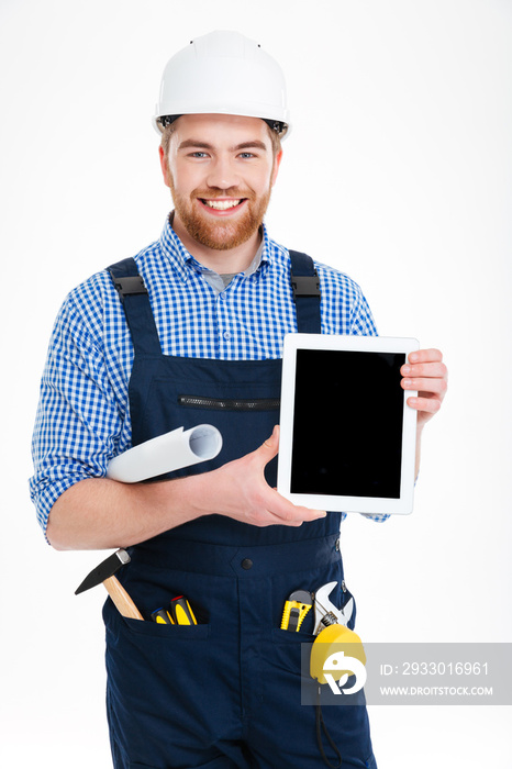 Smiling handsome young builder holding blank screen tablet