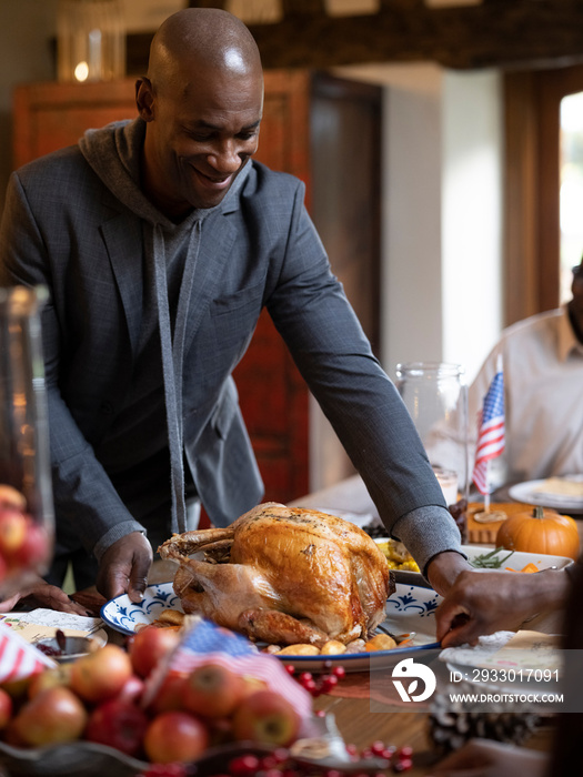 Man putting turkey on Thanksgiving table