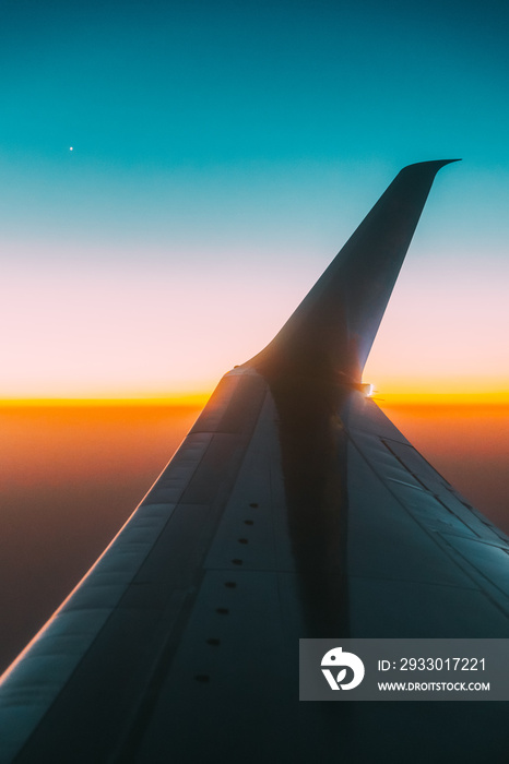 Close View Of On Wing Of Aircraft. Plane At Sunset Sky. View From Airplane Window On Height Flight Of Plane. Travel And Transportation Concept