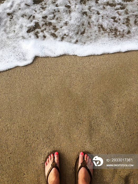 Vertical view of toes on the beach sand