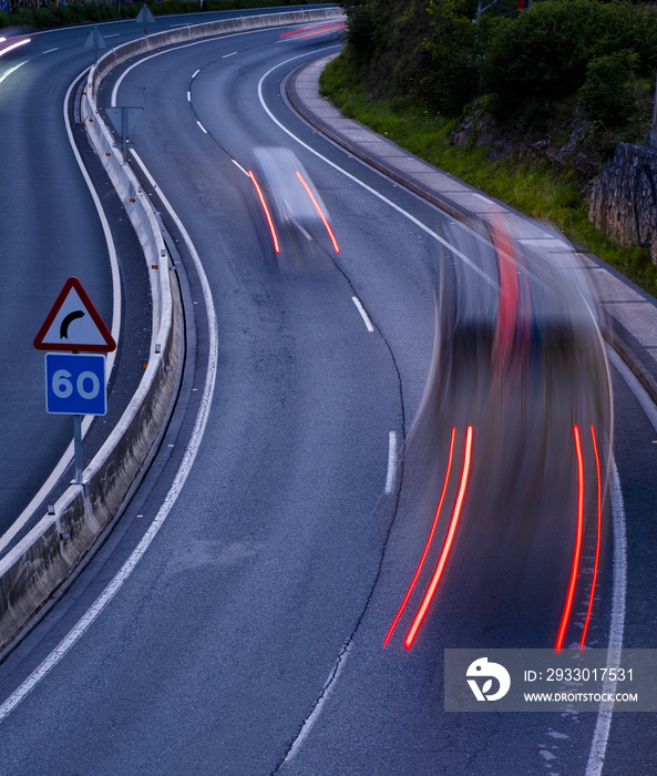 Car lights at night on road curves