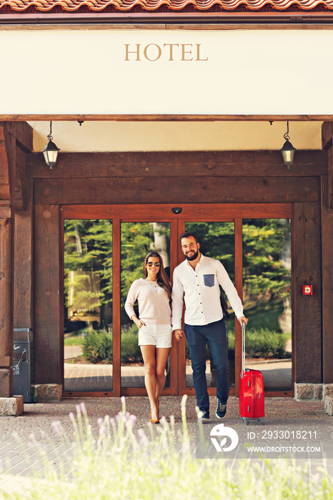 Pretty couple walking out of hotel