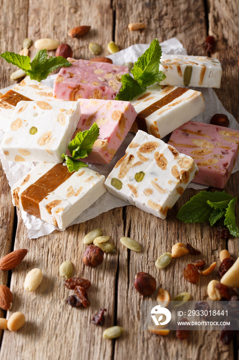 Sweet nougat with nuts, decorated with mint closeup on the paper. vertical