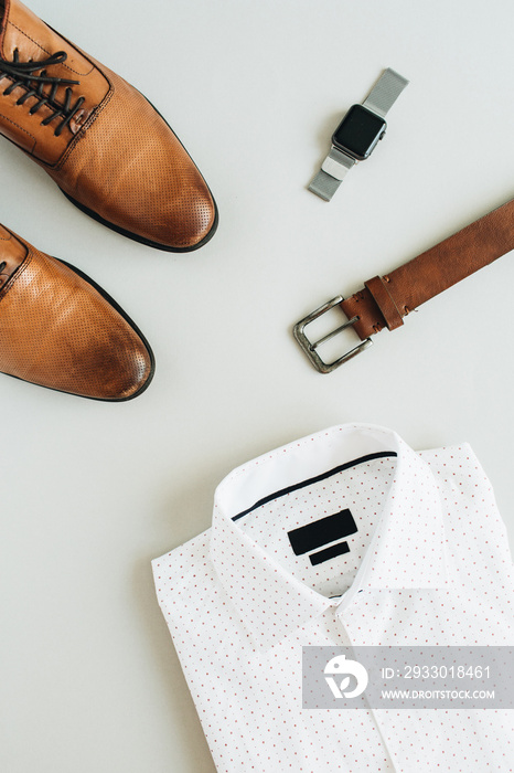 Men’s fashion composition with watch, shirt, belt and shoes. Flat lay, top view modern clothes.