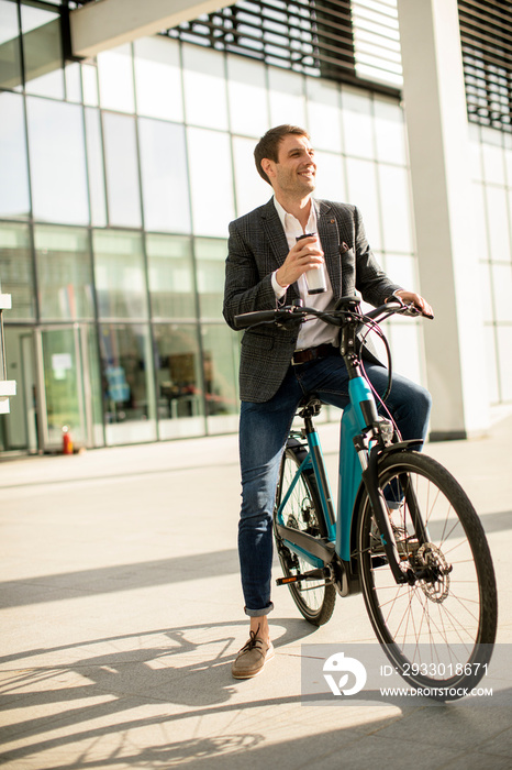 Young businessman on the ebike with takeaway coffee cup