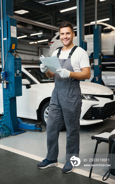 Male checking car documents during car repiar