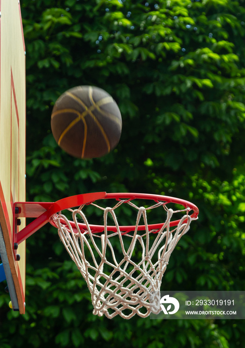 A basketball in the net. The fly ball is in the ring. A sports game. Conceptual: victory, success, hitting the target, sport. Successful ball throw