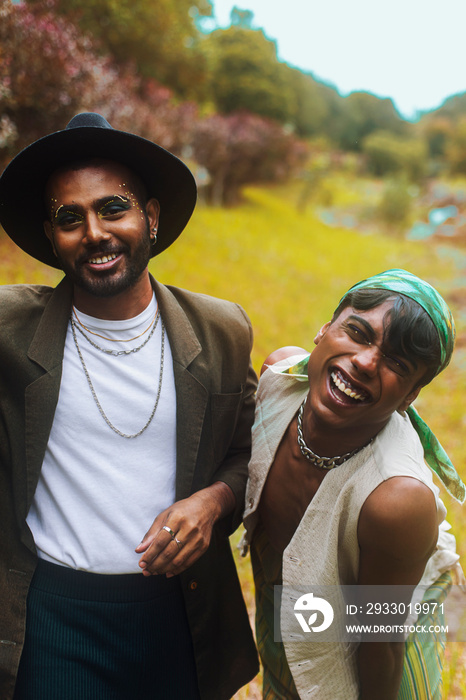 Two Malaysian Indian men surrounded by nature, walking in the grass, laughing together