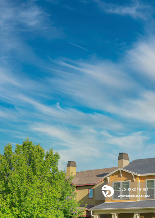 Vertical Whispy white clouds Home exterior with colorful shingles siding at Daybreak, Utah