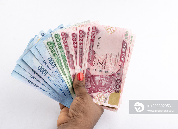 Black Female hand holding the (New) Nigerian currency banknotes , the Naira with a white background