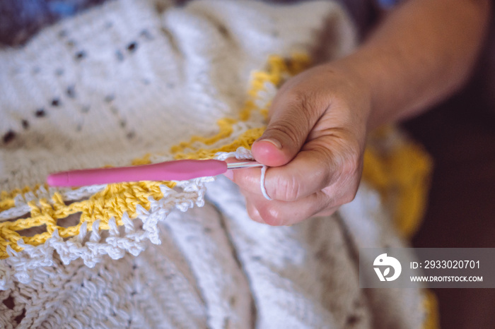 Hands of a woman lady make crochet beautiful embroidered rug