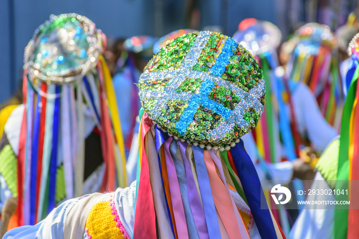 Men dressed in colorful clothes and hats attending a popular religious festival in Minas Gerais, Brazil