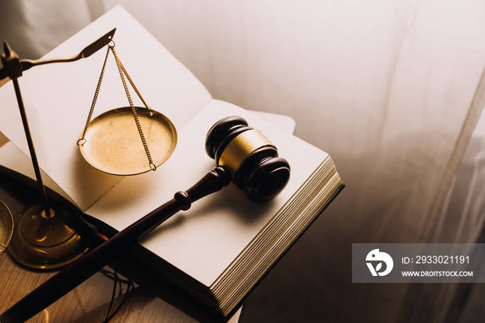 Justice and law concept.Male judge in a courtroom with the gavel, working with, computer and docking keyboard, eyeglasses, on table in morning light