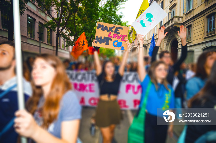 Tilt Shift of people holding picket signs climing for climate change in strike protest  - Activist manifestating claiming for changing in climate politics