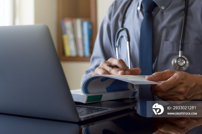 doctor working on laptop and read book