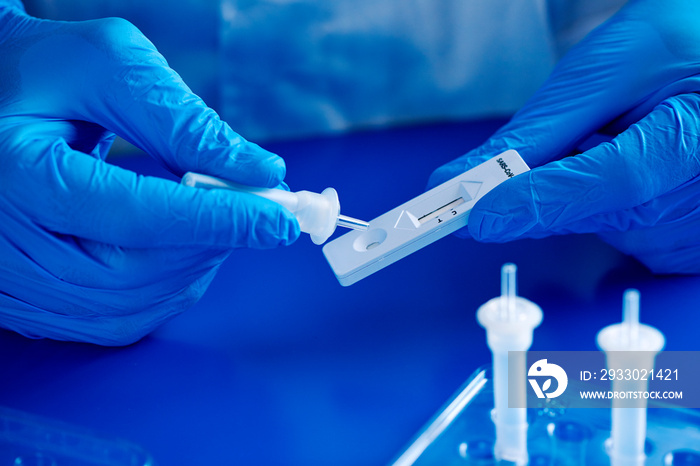 man uses a covid-19 rapid antigen test in the lab