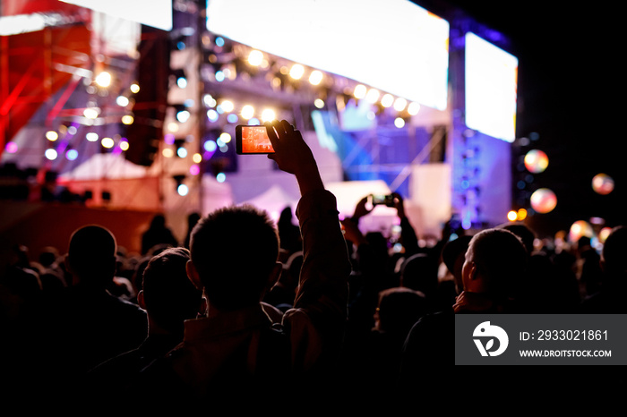 Silhouette of using a mobile phone at a concert.