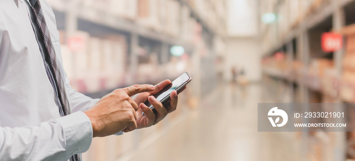 Businessman using smart phone in shopping mall warehouse background and copy space.Concept of people shopping online technology.