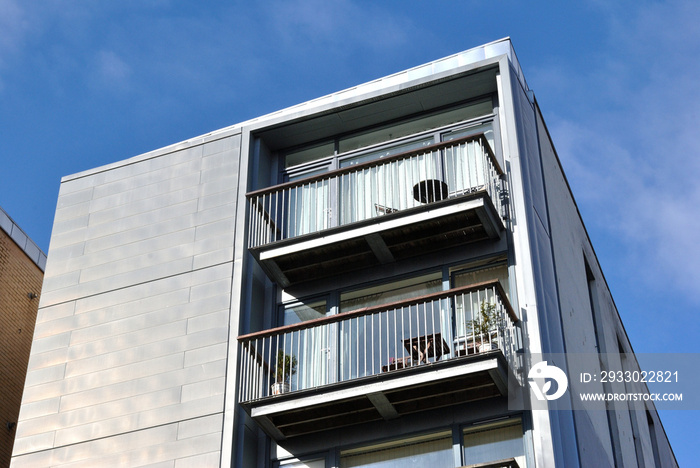 Metal Balconies on Apartment Building seen from Below against Blue Sky