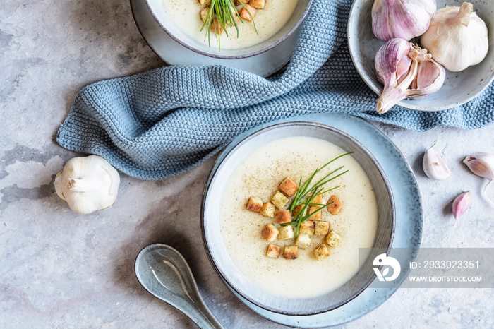 Creamy garlic soup topped with croutons and chives