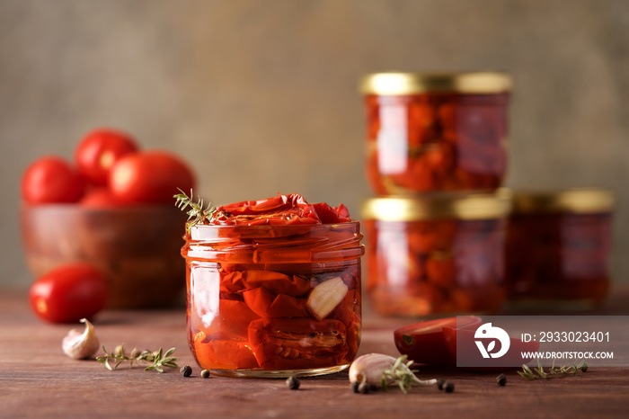 Sun-dried tomatoes in jar with spices and herbs. Autumn seasonal pickled or fermented colorful vegetables. Fall home food preserving or canning