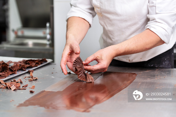 Professional confectioner making chocolate sweets at confectionery shop .