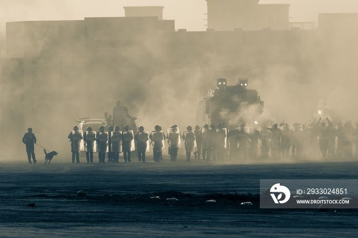 Military police riot response to a protest with tear gas, smoke, fire, explosions. Political expression, riot, protest, demostration and military concept.