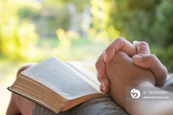 Christian worship and praise. A young woman is reading the Bible in the early morning